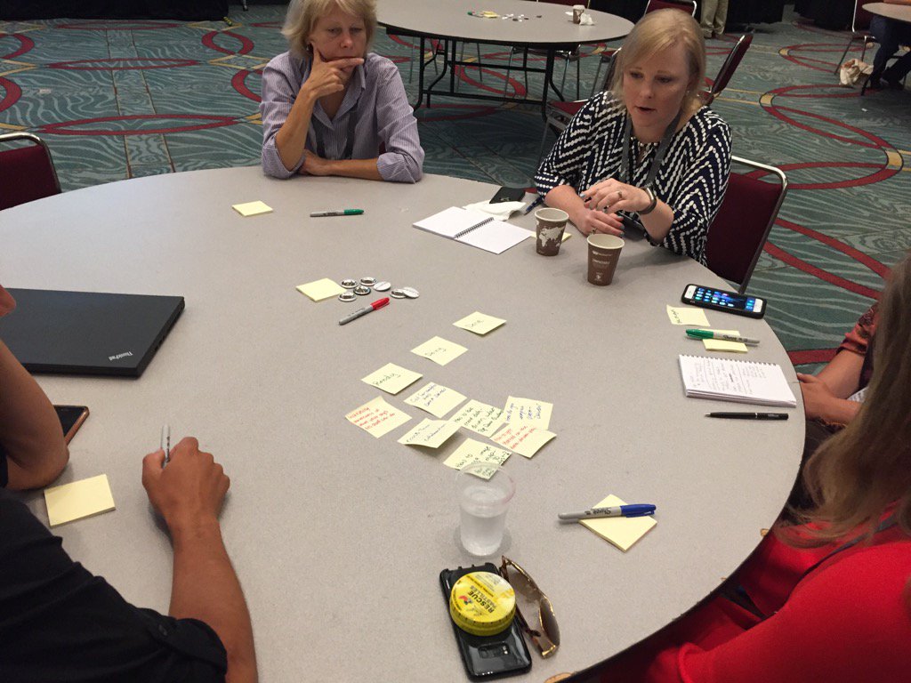 Group discussion at a round table with sticky notes on table