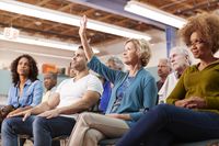 A woman asks a question in a meeting.